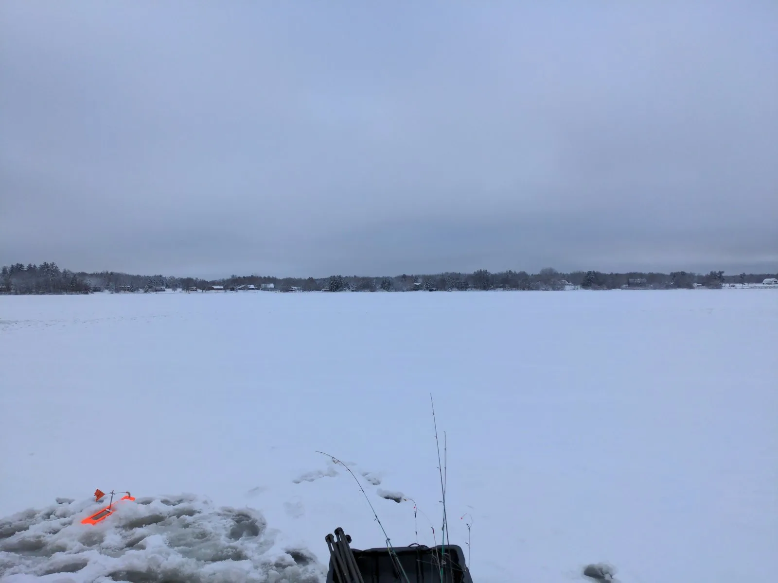 Tip-up flags and fishing rods on a snow-covered frozen lake